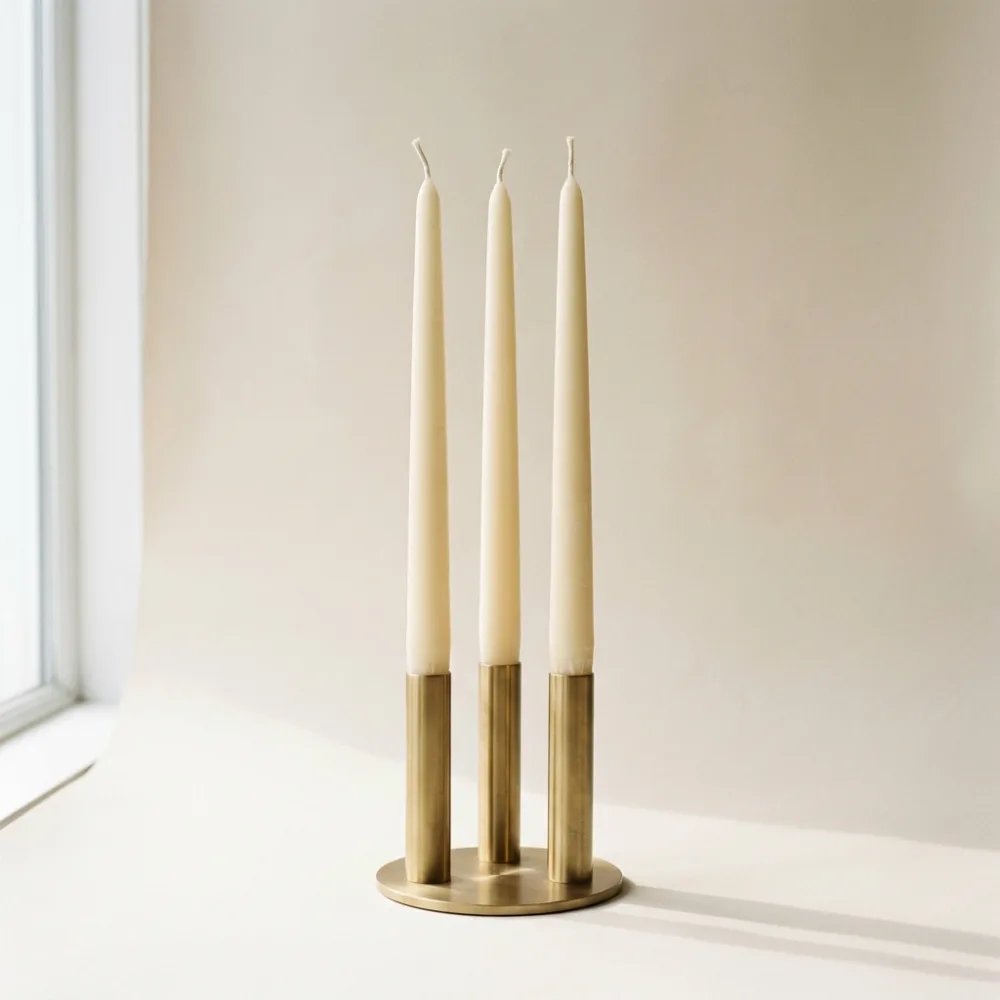 Three ivory beeswax tapers in a brass holder