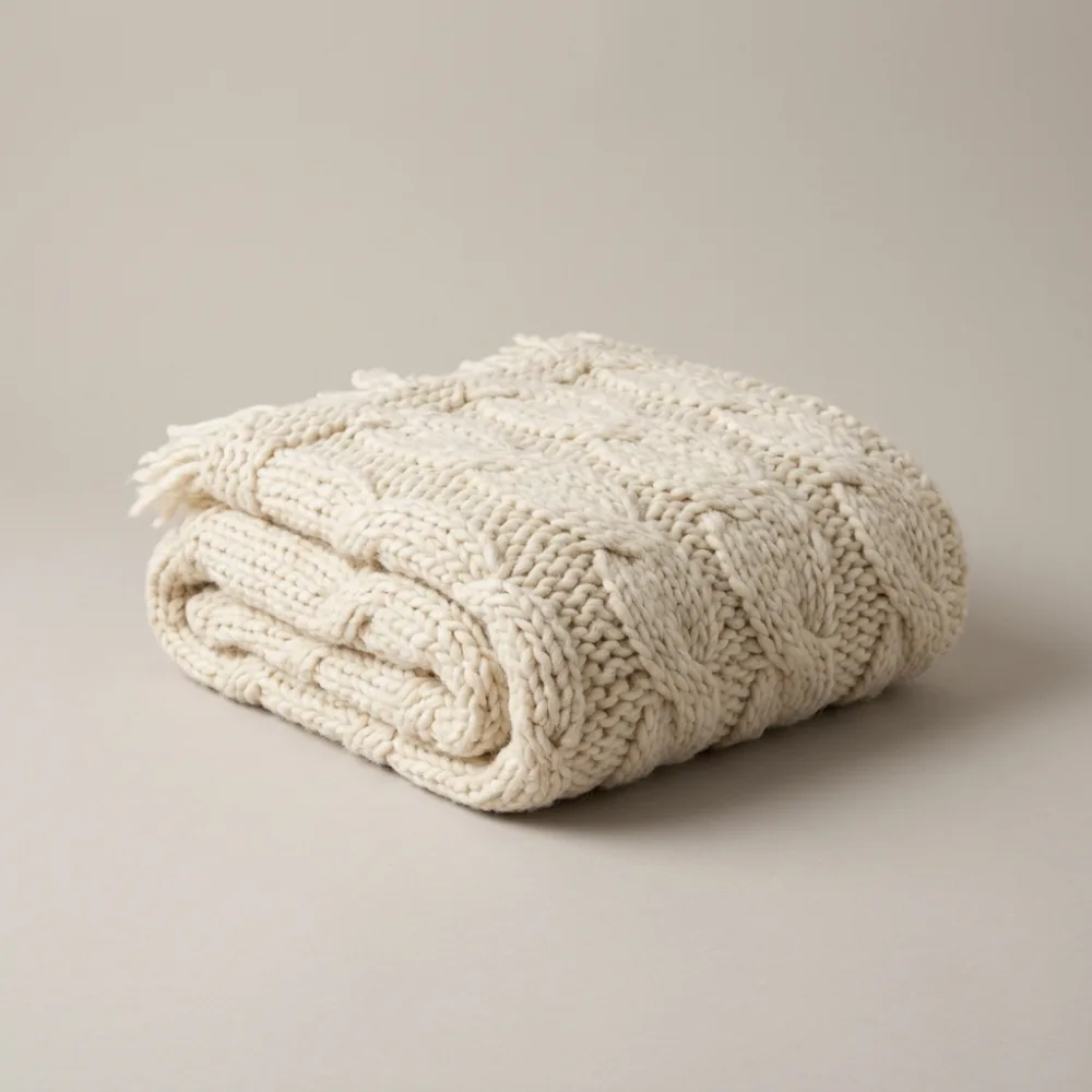 Folded cream chunky knit throw
